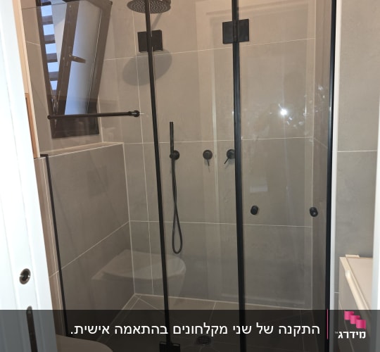 מקלחון פינתי עם זכוכית שקופה ופרזול שחור בחדר רחצה מעוצב